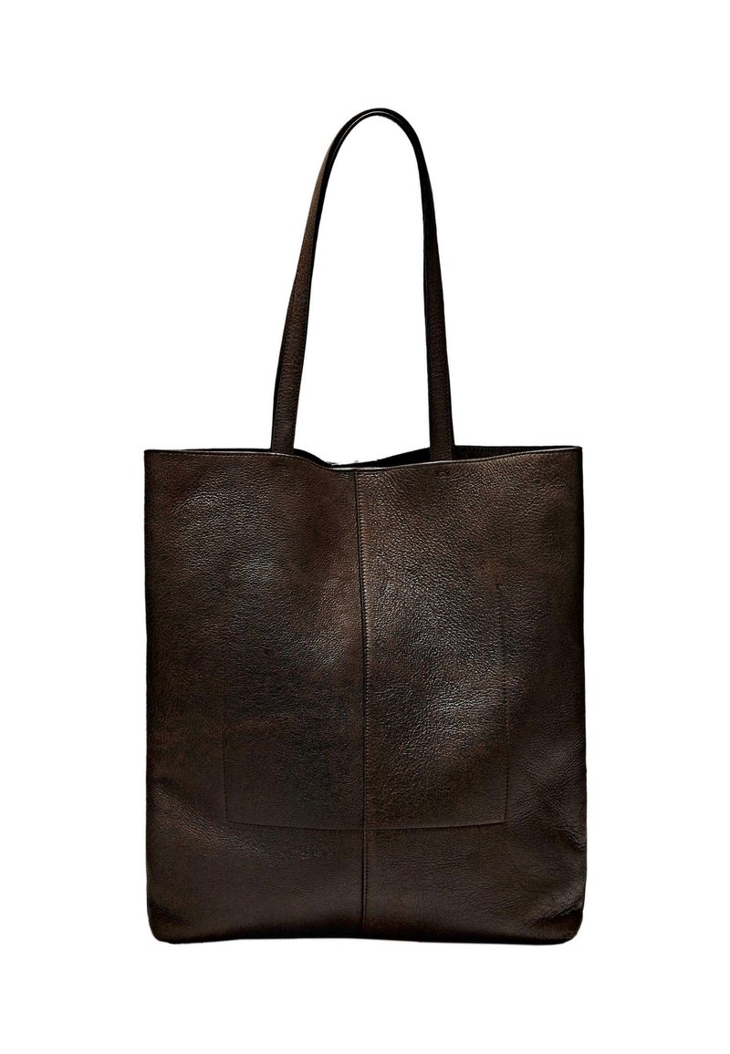 Bruine leren tote bag met een eenvoudige rechthoekige vorm, voorzien van twee lange handvatten en twee voorste patchzakken. Glad van structuur.