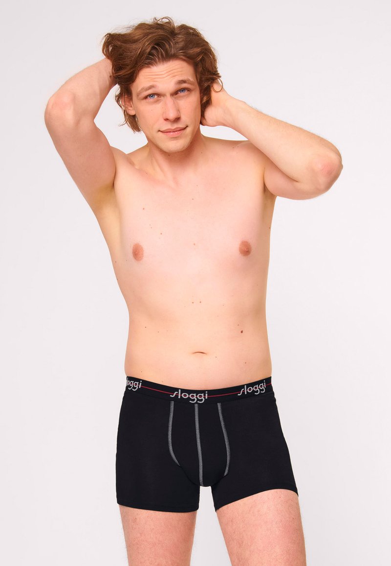 Boxer da uomo neri in cotone con elastico grigio in vita e logo del brand rosso; design aderente con dettagli cuciti nella parte frontale.