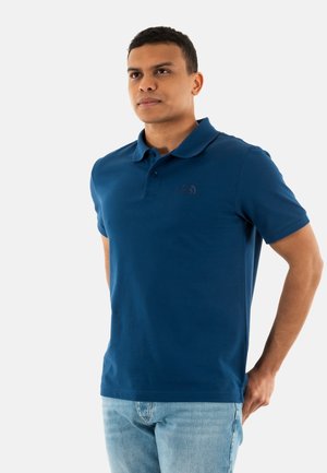 Camisa polo de color azul marino hecha de algodón, con cuello clásico, tapeta de tres botones y un sutil detalle de logo en el pecho.