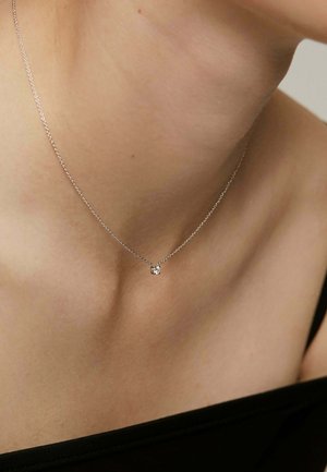 Collar de cadena de plata con un pequeño colgante de piedra preciosa clara. Diseño simple con un patrón de eslabones delicado y textura suave.