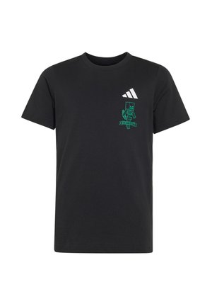 Camiseta negra de manga corta con pequeño logo blanco de Adidas y personaje pixelado verde de Minecraft con una pancarta en la parte superior izquierda del pecho.