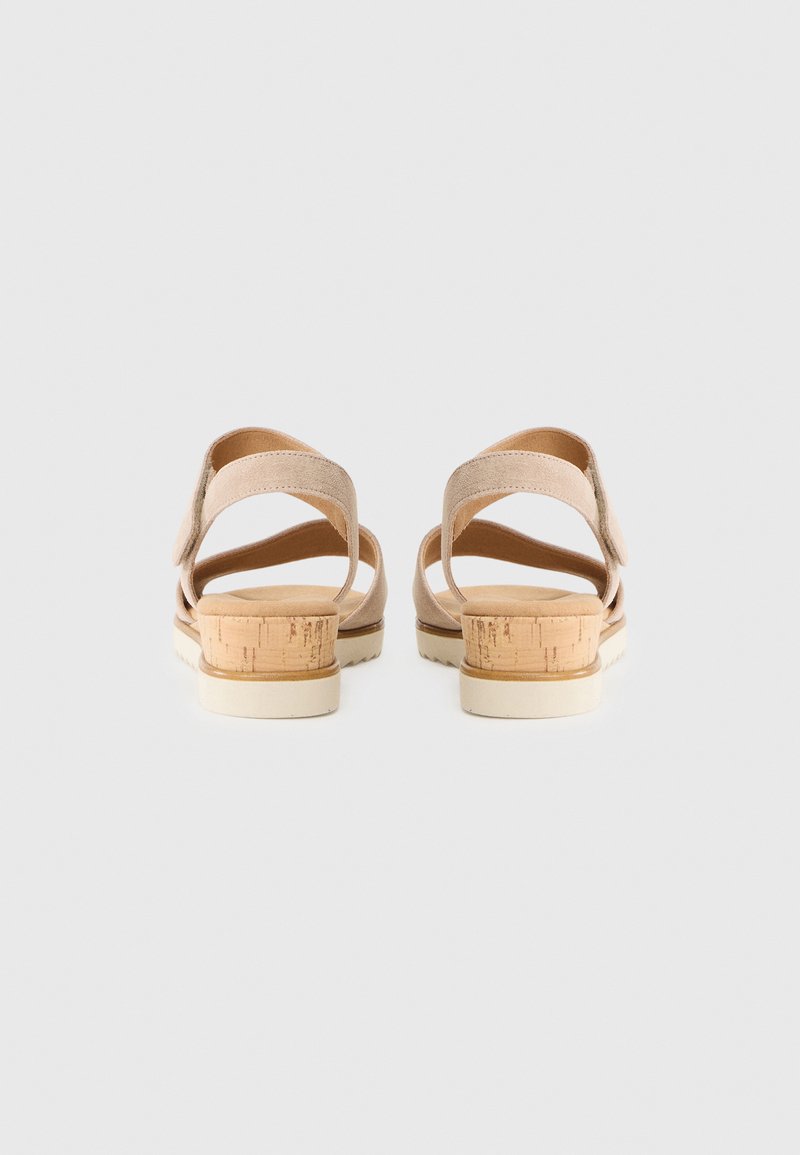 Beige Riemchensandalen mit einem Korkabsatz und strukturiertem Fußbett, ausgestattet mit einer Gummisohle für besseren Halt und verstellbaren Riemen für mehr Komfort.