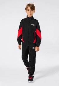 Black tracksuit with red accents and zipper jacket, featuring a logo and 19@19 text on the chest and pants. Soft fabric, athletic fit.