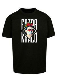 Svart bomull t-skjorte med et grafisk motiv av en kvinne med malt ansikt og blomster i håret, med teksten "FRIDA KAHLO" i fet skrift.