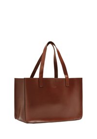 Sac fourre-tout en cuir marron avec une texture lisse, de forme rectangulaire et deux poignées robustes ; présente un branding subtil sur un côté.