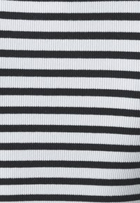 Black and white horizontally striped fabric with a ribbed texture, featuring alternating thick and thin stripes.