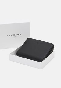 Schwarze Leder Geldbörse mit glatter Textur, Reißverschluss und geprägt Logo der Marke. In einer weißen Box mit dem Markennamen auf dem Deckel präsentiert.