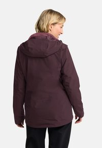 Giacca impermeabile bordeaux con cappuccio, colletto testurizzato e vestibilità rilassata. Tessuto liscio con una leggera lucentezza e senza dettagli hardware visibili.