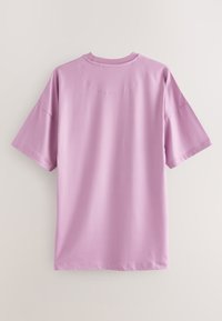 Schlichtes hellviolettes T-Shirt mit kurzen Ärmeln und Rundhalsausschnitt, von hinten vor neutralem Hintergrund gezeigt.