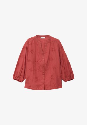 Blusa roja de algodón con cuello mandarín, botones en el frente y mangas cortas abullonadas. Presenta un bordado con motivo floral en toda la tela.