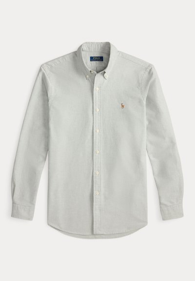 Ανοιχτό γκρι πουκάμισο με γιακά με κουμπιά, μακριά μανίκια και κεντημένο λογότυπο στο αριστερό στήθος. Διαθέτει μανσέτες με κουμπιά και απαλό ύφασμα.