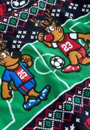Strickstoff mit zwei Cartoon-Rentieren, die Fußball spielen; eines in Blau mit roten Akzenten, das andere in Rot mit weißen Highlights, vor einem gemusterten Hintergrund.