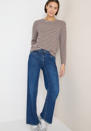 Gestreiftes langärmliges Oberteil in Braun und Weiß mit rundem Ausschnitt, kombiniert mit blauen Jeans mit weitem Bein und klassischem Five-Pocket-Design.