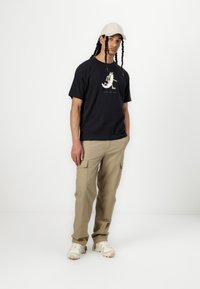 New Balance BEARDED RUNNER UNISEX - Apdrukāts T-krekls - black