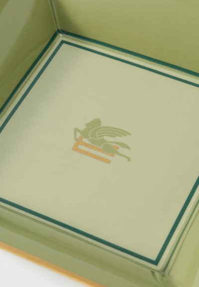 Bandeja de vidrio con un borde verde y un emblema de caballo alado en dorado y verde en el centro.