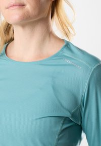 Camisetta a maniche lunghe di colore azzurro chiaro realizzata in tessuto testurizzato, con collo rotondo e il logo "SWEDMOUNT" ricamato sulla spalla.