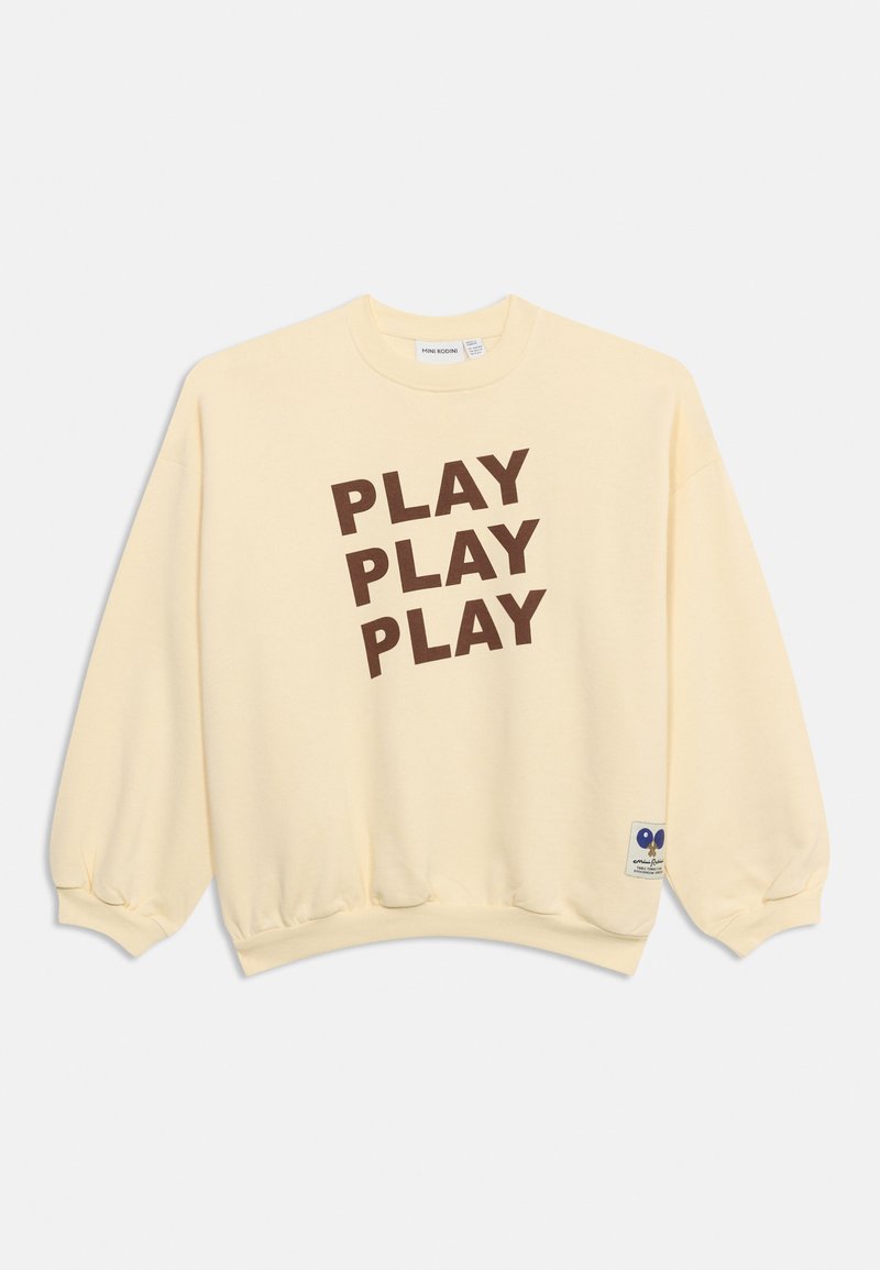 Φούτερ σε κρεμ χρώμα με τρεις καφέ λέξεις "PLAY" στοιχισμένες διαγώνια στο μπροστινό μέρος και μικρό μπλε καρδιόσχημο έμβλημα κοντά στο τελείωμα.