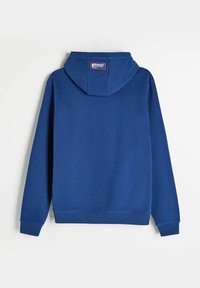 Niebieska bluza z kapturem wykonana z miękkiej tkaniny, z kapturem na sznurki, ściągaczami przy rękawach i w pasie, z etykietą z tyłu w pobliżu dekoltu.