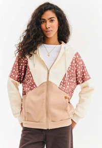 Bluza z kapturem na zamek błyskawiczny o wzorze w blokach kolorów w kolorze kremowym, różowym i brązowym; posiada polka dot akcenty i przednie kieszenie.