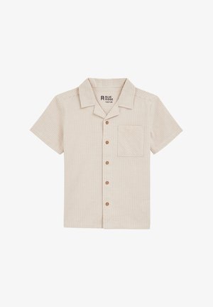 Švarkas trumpomis rankovėmis, su mygtukais, šviesiai rudos spalvos su šviesiai rudos vertikaliais dryžiais. Turi krūtinės kišenę ir medinius mygtukus. Pagamintas iš tekstūruoto audinio.