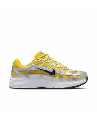 Gelbe und silberne Laufschuhe mit Mesh-Obermaterial, strukturierten Schnürsenkeln und schwarzen Akzenten. Sie verfügen über eine gepolsterte weiße Zwischensohle und eine Gummisohle.