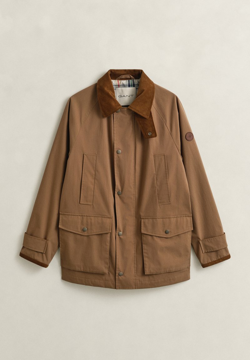 Veste décontractée marron avec col en velours côtelé, boutons-pression, quatre poches avant et bracelets de poignet ajustables, posée à plat sur un fond clair.