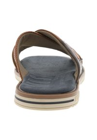 Sandales en cuir marron au design courbé, avec des sangles en tissu et une semelle intérieure bleue texturée. Elles possèdent une semelle en caoutchouc à profil bas avec des lignes d'accent.