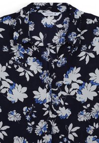 Blusa floreale blu navy con fiori bianchi e blu. Presenta un colletto, una chiusura con bottoni e un tessuto morbido e leggero.