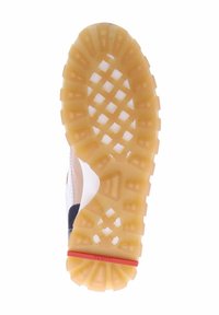 Shoe outsole featuring a textured, gum rubber material in a honeycomb pattern, with a red accent and a curved edge design.