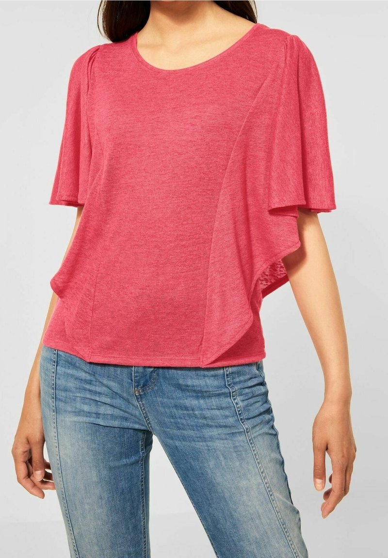 Czerwony top z krótkim rękawem, dekoltem w serek i marszczonym wzorem, wykonany z miękkiego, lekkiego materiału. Dopasowany do dżinsów.