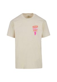 Krämfärgad bomull t-shirt med rund hals som har rosa och orange text som säger "KRÄV EN SLUT PÅ POLISBRUTALITET NU!" samt en grafik av en knuten näve.