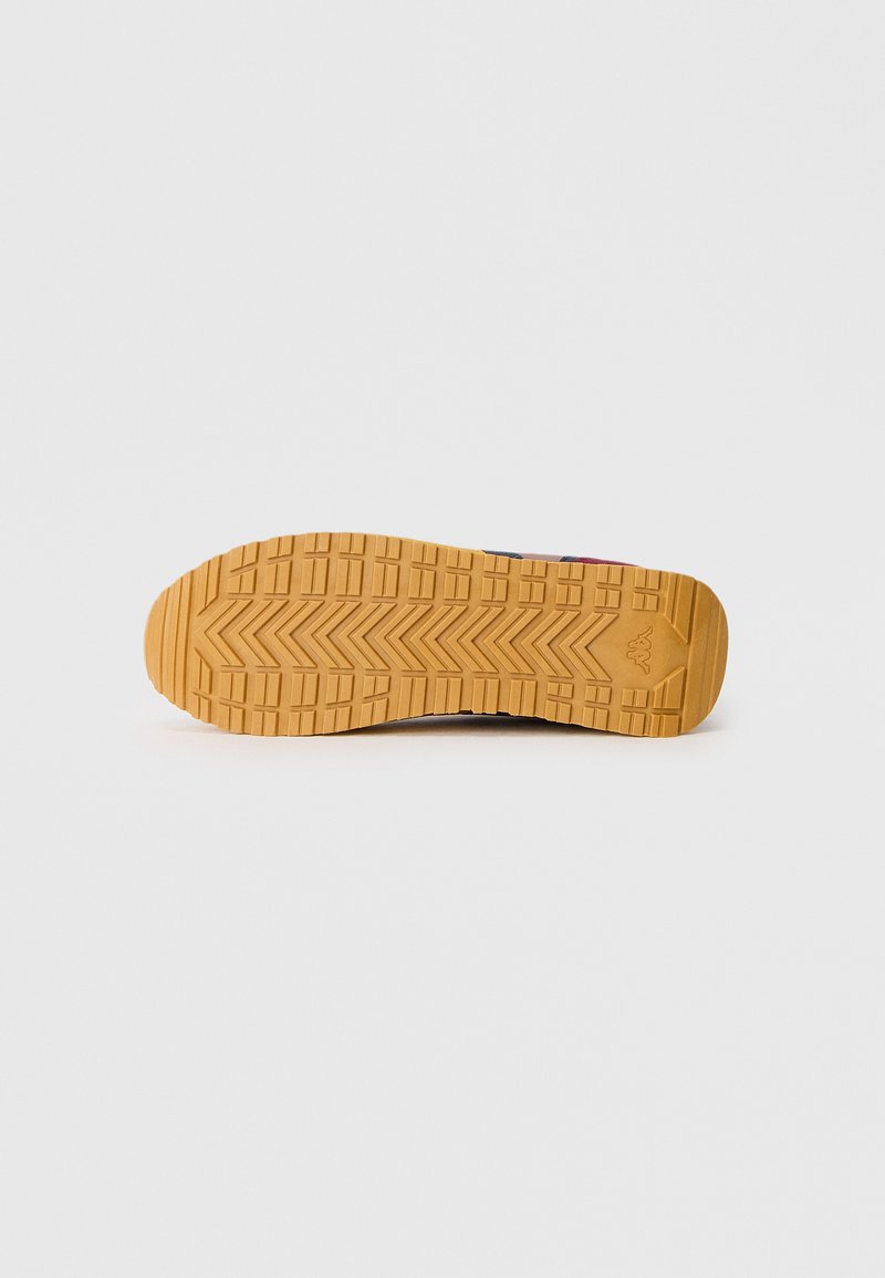 Suola della scarpa in gomma marrone con una presa testurizzata e pattern, dotata di un design a zigzag per una maggiore aderenza e durata.