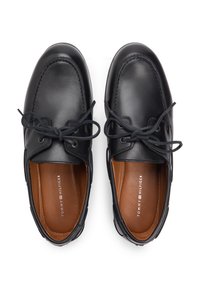 Μαύρα δερμάτινα παπούτσια με στρογγυλεμένη μύτη, ραμμένες λεπτομέρειες και σχέδιο με κορδόνια. Καφέ εσωτερική επένδυση με λογότυπο.