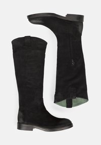 Botas de ante negras hasta la rodilla con puntera redondeada, suela lisa, cremallera lateral y forro verde. Presentan un tacón corto y una lengüeta en la parte superior.