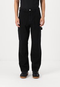 Sorte cargo bukser med en afslappet pasform, der har frontlommer, sidelommer og en glat tekstur. Sæt sammen med sorte sneakers.