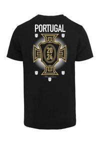 Sort t-shirt med et stort guld-emblem med teksten "2024" og "PORTUGAL" ovenfor, sat mod en prikket baggrund.