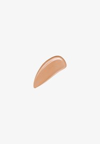 Crème beige avec une texture lisse et brillante, façonnée en une forme courbée et allongée, adaptée à une application cosmétique.