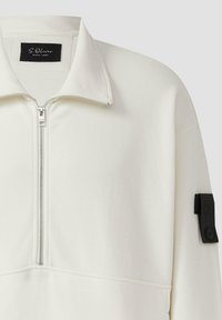 Weißer Zip-Up-Pullover mit hohem Kragen, ausgestattet mit einem schwarzen Etikett am Ärmel und glatter Textur. Leichtes Material mit genähten Nähten.