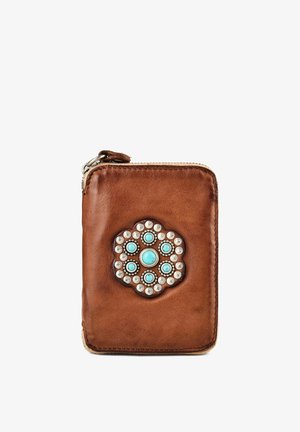 Braune Lederbrieftasche mit einer silbernen und türkisfarbenen, blumenförmigen Niete in der Mitte und einem Reißverschluss oben.