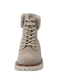 Botín de tobillo de ante beige con un cuello de piel sintética, diseño de cordones, ojales metálicos y una suela rugosa de color crema, que muestra una textura suave.