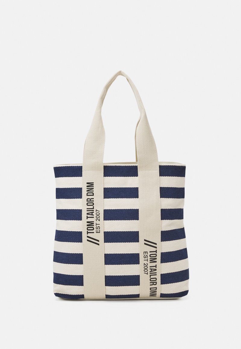 Sac fourre-tout en toile rayée bleu marine et blanc avec des poignées couleur crème, arborant un logo en texte noir sur le côté. Forme rectangulaire.