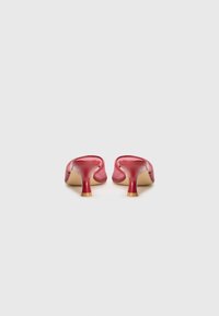 Red high-heeled shoes with a glossy finish, pointed toe design, and a slim heel. Smooth texture with minimal detailing, set against a white background.