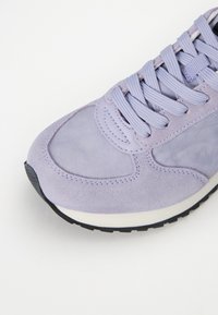 Lilla sneakers med semsket skinn og mesh-materialer, rund tåform, flate snører, og en teksturert gummisåle for godt grep.