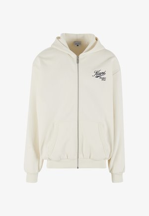 Krémová mikina na zips s kapucňou, prednými vreckami, rebrovanými manžetami a čiernym logo v písme na ľavej strane hrude. Mäkká, textúrovaná tkanina.