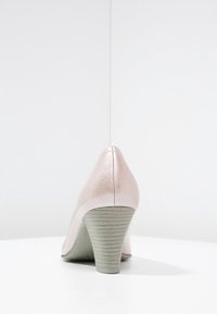 Vaaleanpunaiset synteettiset viistopohjaiset kengät, joissa on teksturoitu pinta, pyöreä varvasosa ja vaaleanharmaa puumainen korko.