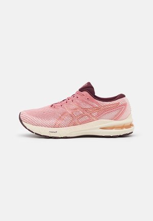 Pink and maroon running shoe with cushioned sole and breathable knit upper, side view on white background.