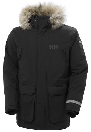 Parka negra aislada con capucha forrada de piel sintética, bolsillo en el pecho con cremallera, dos bolsillos frontales y un acento reflectante en la manga.