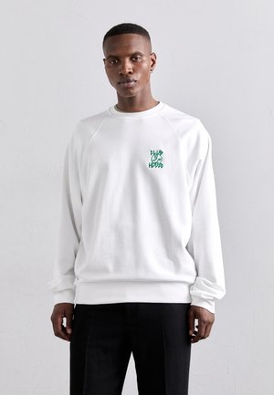 White sweatshirt with ribbed cuffs and hem, featuring a green graphic logo on the left chest; soft material with a relaxed fit.