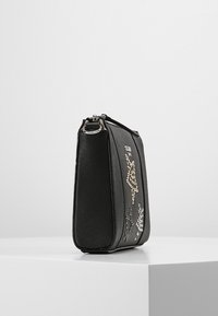 Svart rektangulär handväska med texturerade sidor, silverdetaljer och guld- samt silverblommor som prydnad på frampanelen.