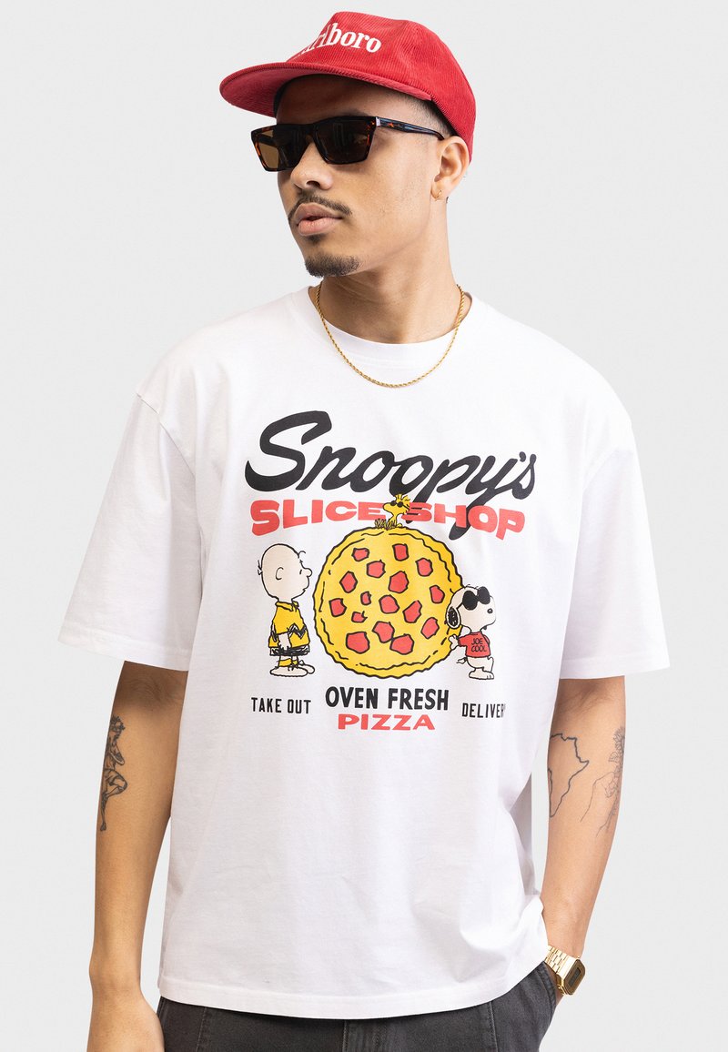 Hvid bomulds T-shirt med et farverigt tegneserieprint af Snoopy og vennerne med en pizza, sort tekst og et afslappet fit design.